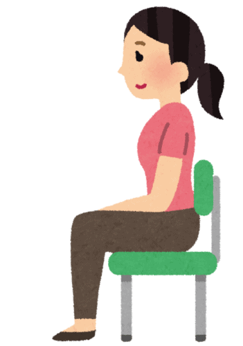 背筋を伸ばして椅子に座る女性。